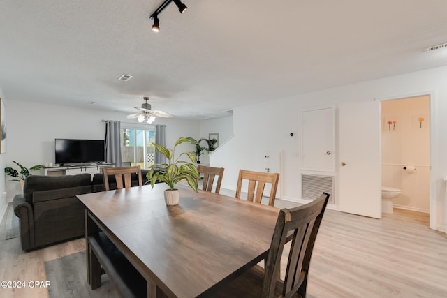 dining space featuring ceiling fan, a textured ceiling, and light hardwood / wood-style flooring