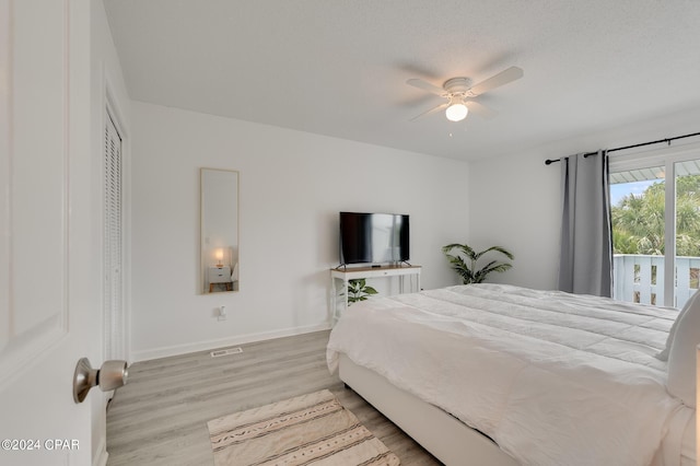 bedroom with a textured ceiling, a closet, light hardwood / wood-style flooring, and ceiling fan