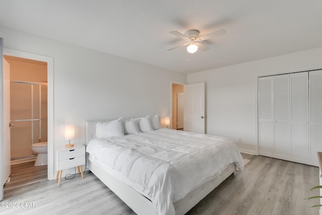 bedroom with ensuite bath, a textured ceiling, ceiling fan, light hardwood / wood-style floors, and a closet