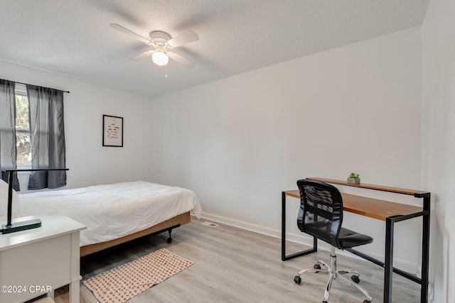 bedroom featuring ceiling fan, a textured ceiling, and light hardwood / wood-style flooring