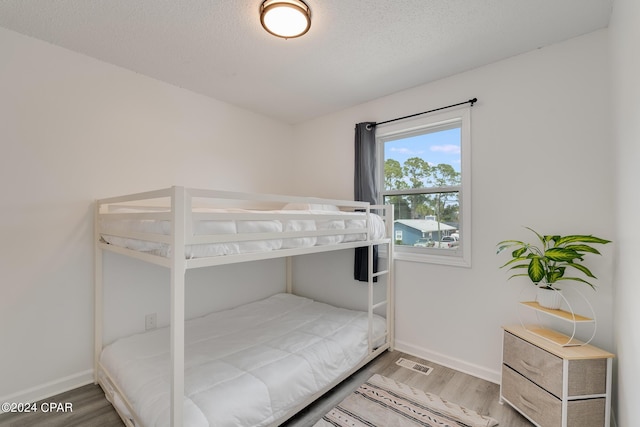 bedroom with hardwood / wood-style flooring and a textured ceiling