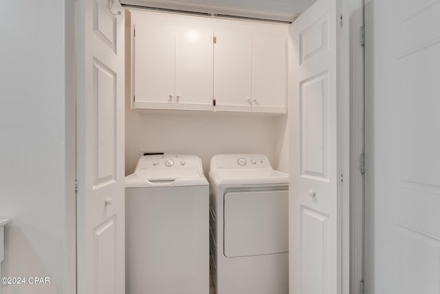 washroom featuring cabinets and washing machine and clothes dryer