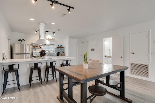 dining area with light wood-type flooring and sink