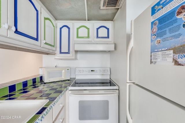 kitchen featuring white cabinets, tile countertops, and white appliances