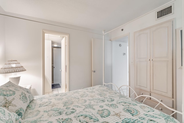 bedroom with a closet and light tile floors