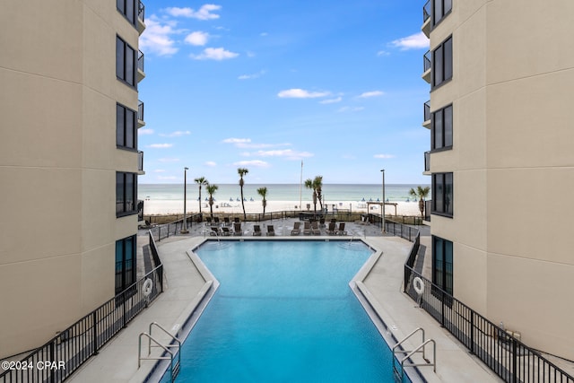 view of swimming pool featuring a patio area and a water view