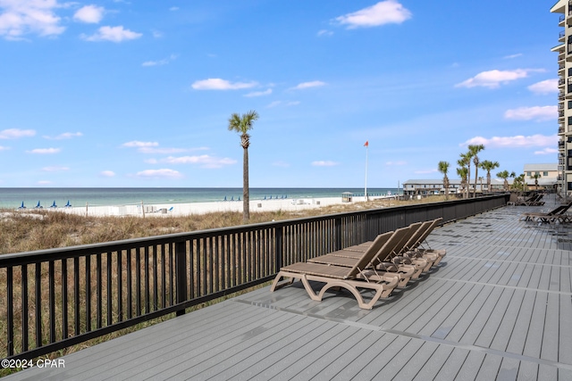 wooden deck with a beach view and a water view