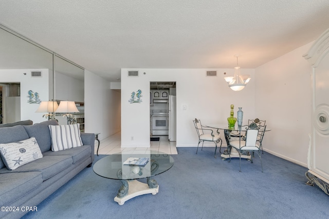 living room with a chandelier, carpet, and a textured ceiling