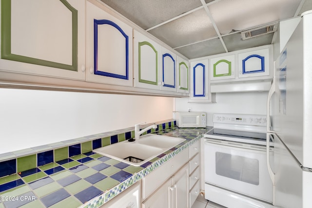 kitchen featuring white cabinets, tile countertops, white appliances, and sink