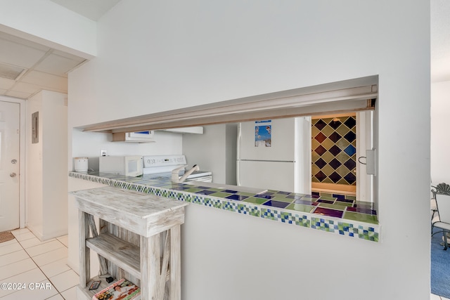 interior space featuring white appliances and light tile floors