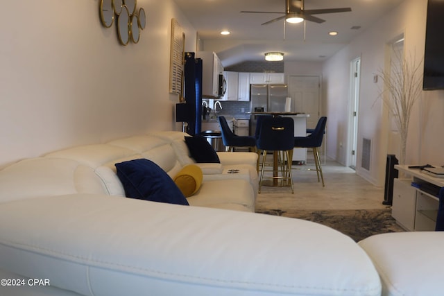 bedroom featuring wood-type flooring, ceiling fan, and stainless steel refrigerator with ice dispenser