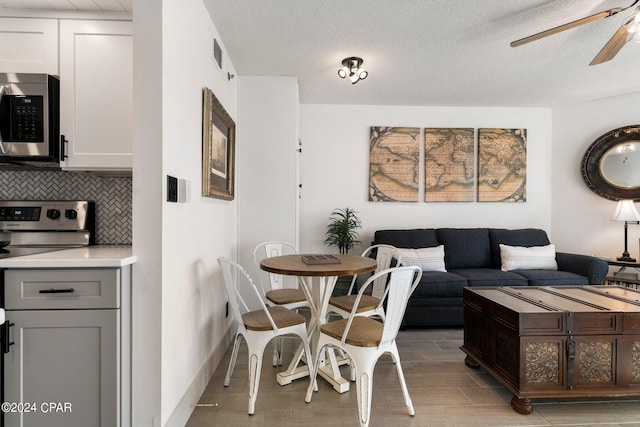 dining space with a textured ceiling and ceiling fan