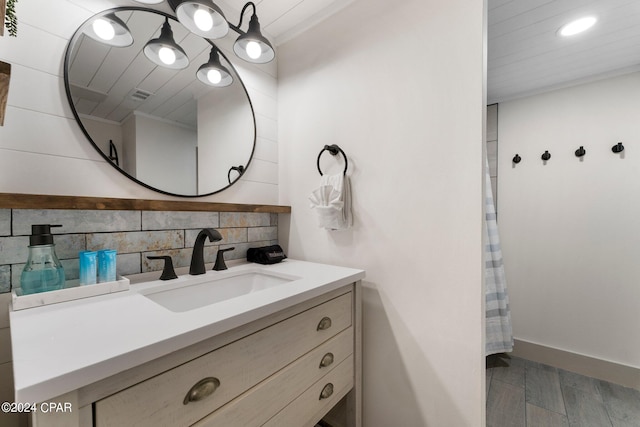 bathroom with oversized vanity, tasteful backsplash, and wood-type flooring