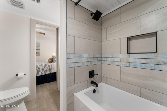 bathroom featuring tile walls, hardwood / wood-style floors, and toilet