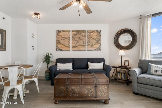 living room with ceiling fan and a textured ceiling