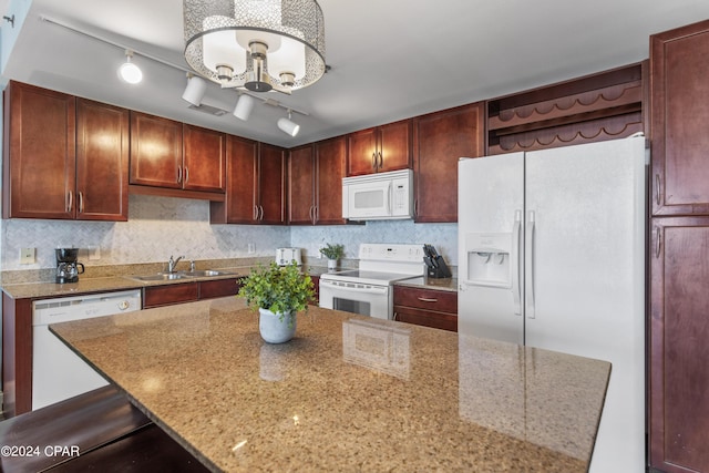 kitchen with sink, light stone counters, decorative light fixtures, white appliances, and decorative backsplash