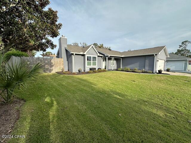 single story home featuring a front yard and a garage