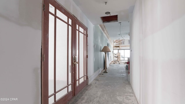 hall featuring french doors and concrete floors