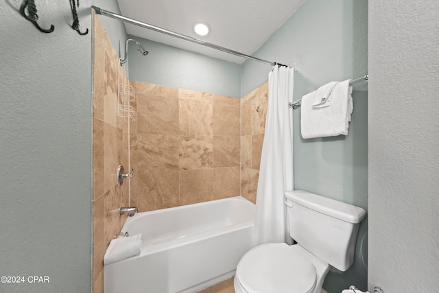 bathroom featuring shower / bath combo with shower curtain, toilet, and a textured ceiling