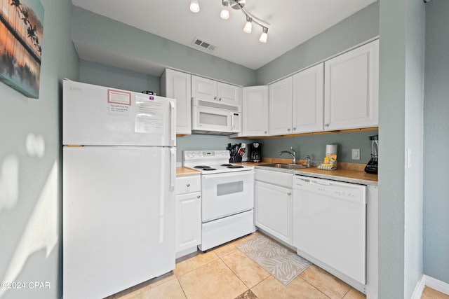 kitchen with white appliances, sink, light tile floors, rail lighting, and white cabinets