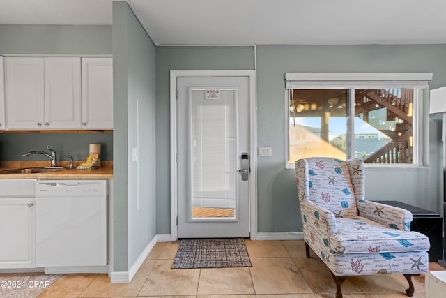 doorway to outside featuring light tile floors and sink