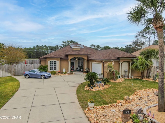 mediterranean / spanish home with a garage and a front lawn