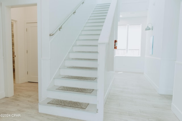 stairway with baseboards and wood finished floors