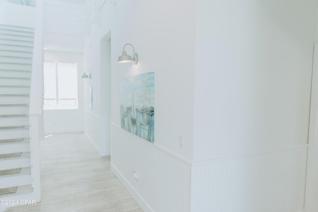 corridor with wainscoting and light wood-type flooring