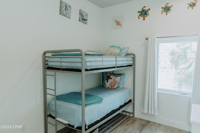 bedroom with baseboards and wood finished floors