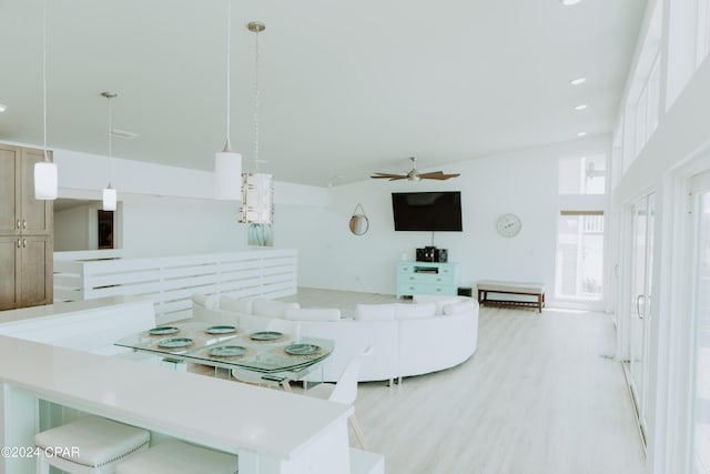 interior space with light wood-style floors, open floor plan, light countertops, and decorative light fixtures