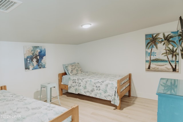 bedroom with visible vents, baseboards, and wood finished floors