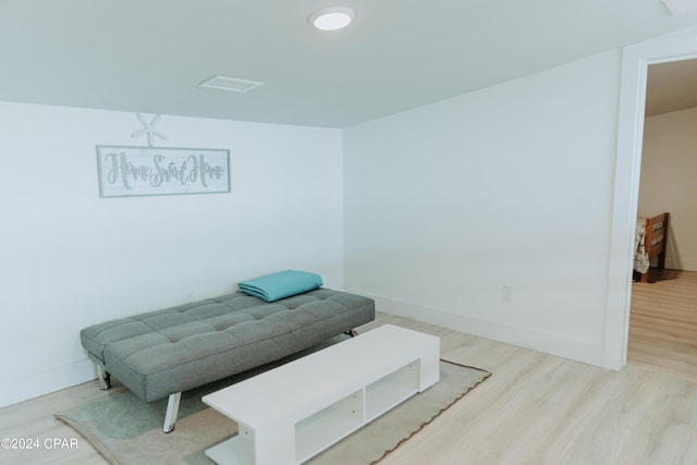 living area with light wood-type flooring, visible vents, and baseboards