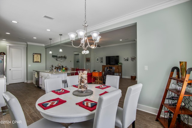 dining space with ornamental molding, a notable chandelier, sink, and dark hardwood / wood-style flooring