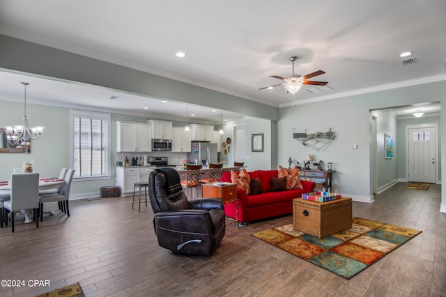 living room with dark hardwood / wood-style flooring, ornamental molding, and ceiling fan with notable chandelier