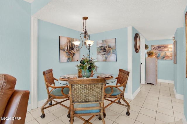 tiled dining area with a textured ceiling and an inviting chandelier