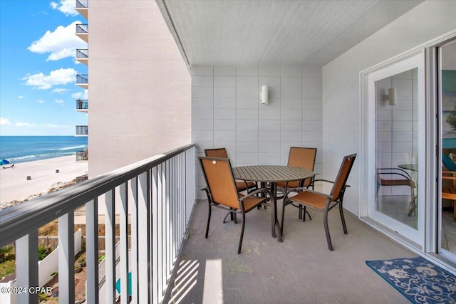 balcony with a water view and a view of the beach