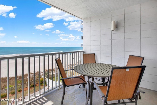 balcony featuring a water view and a view of the beach