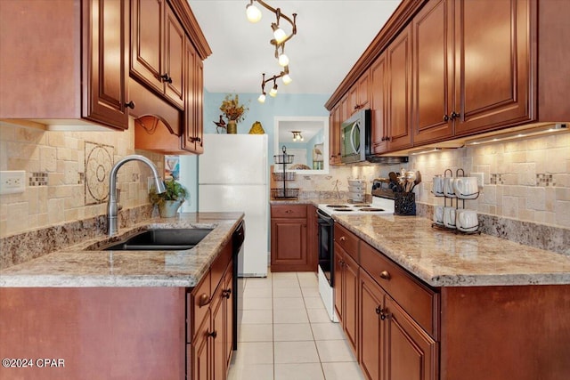 kitchen with tasteful backsplash, white appliances, light tile floors, sink, and rail lighting