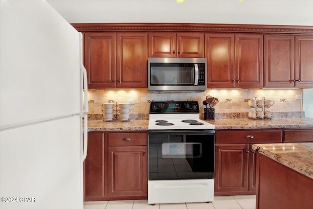 kitchen with backsplash, white appliances, light tile floors, and light stone counters