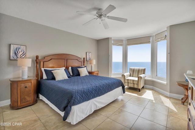 bedroom with a ceiling fan, light tile patterned flooring, baseboards, and a water view