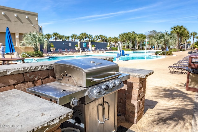 community pool with exterior kitchen and a patio