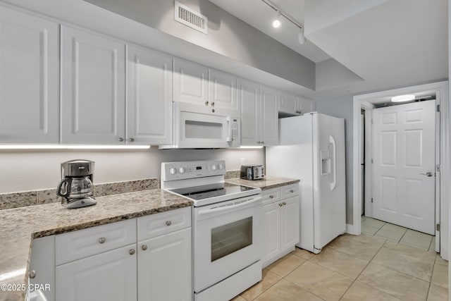 kitchen with visible vents, light tile patterned floors, light stone counters, white appliances, and white cabinetry