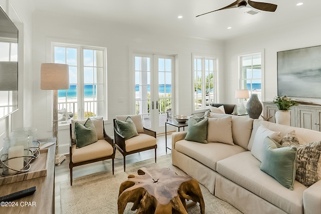 living room with light hardwood / wood-style floors, ceiling fan, french doors, and a wealth of natural light