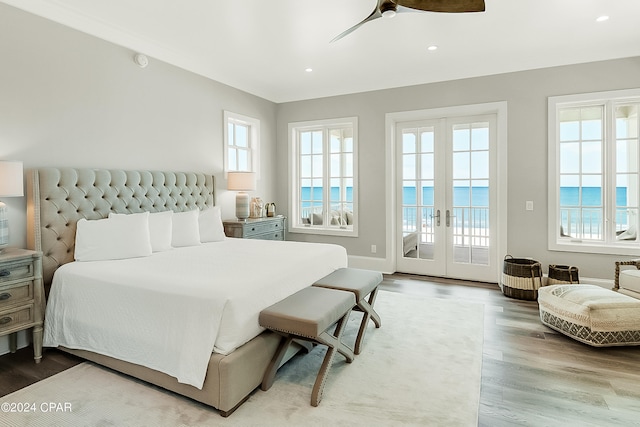 bedroom with multiple windows, ceiling fan, access to exterior, light hardwood / wood-style flooring, and french doors