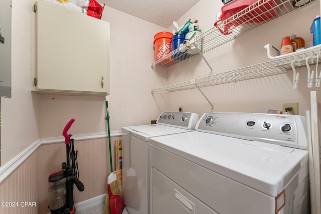 clothes washing area featuring a textured ceiling, cabinets, and independent washer and dryer