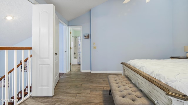 bedroom with vaulted ceiling, wood finished floors, and baseboards