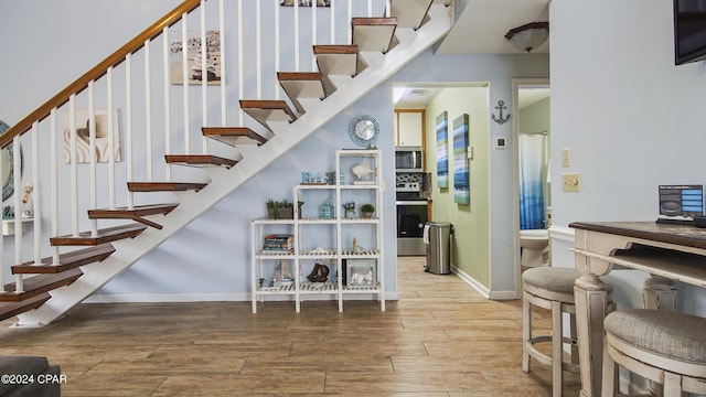 stairway featuring wood finish floors and baseboards