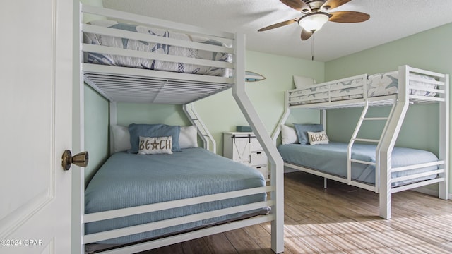 bedroom with ceiling fan, a textured ceiling, and wood finished floors