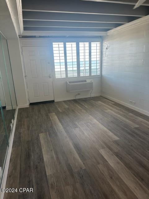 foyer entrance with a wall mounted AC and dark wood-type flooring