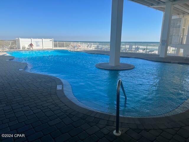 view of pool with a water view and a patio area